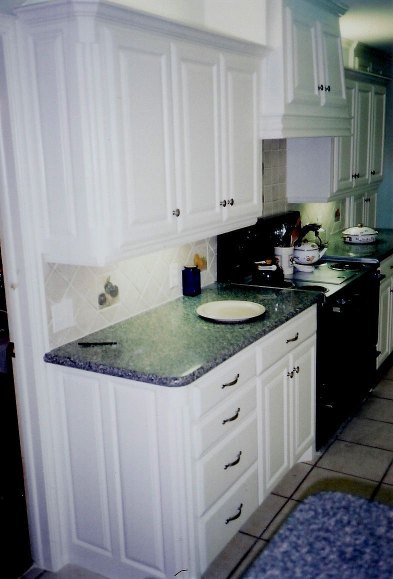 A kitchen with white cabinets and granite counter tops