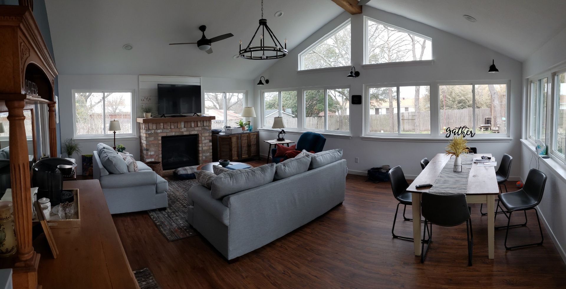 A living room with a couch , table , chairs and a fireplace.