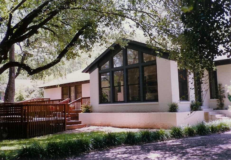 A white house with a black roof and lots of windows