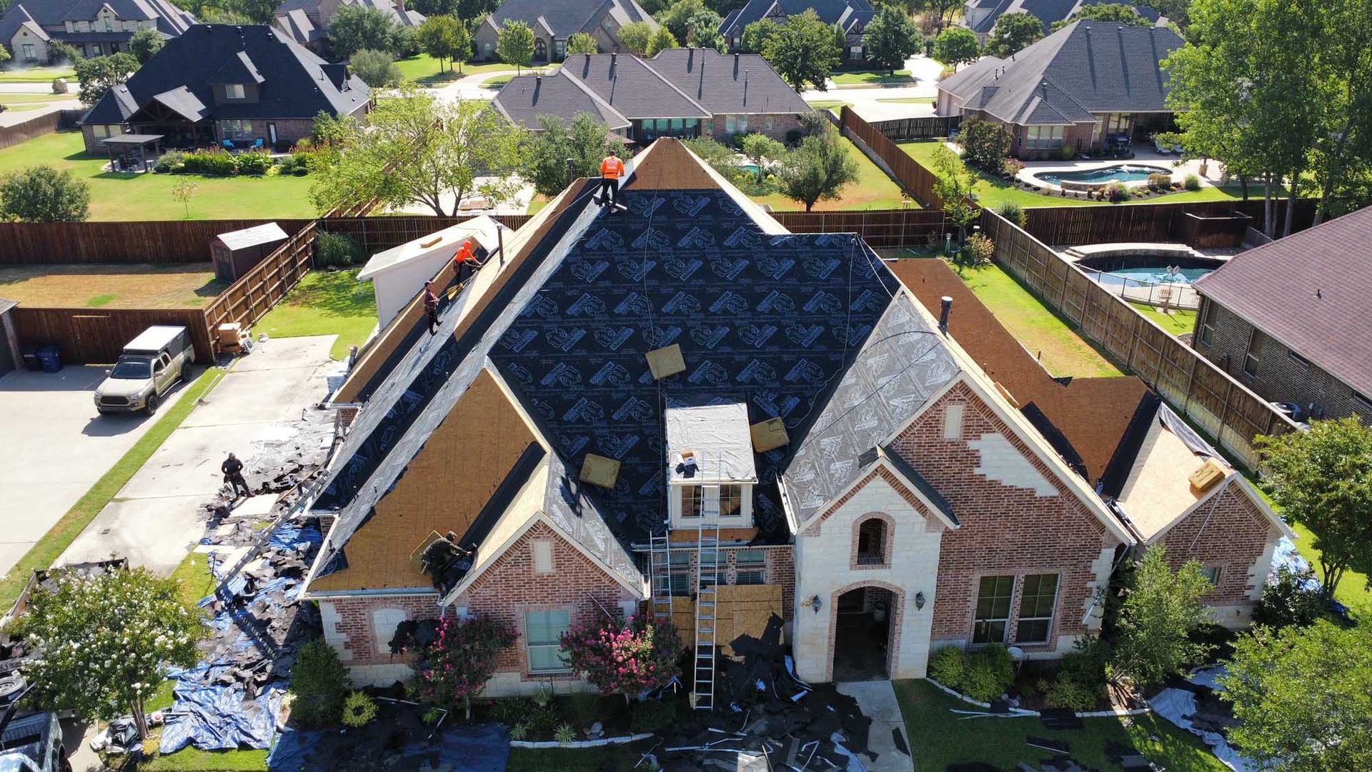An aerial view of a house under construction in a residential area.
