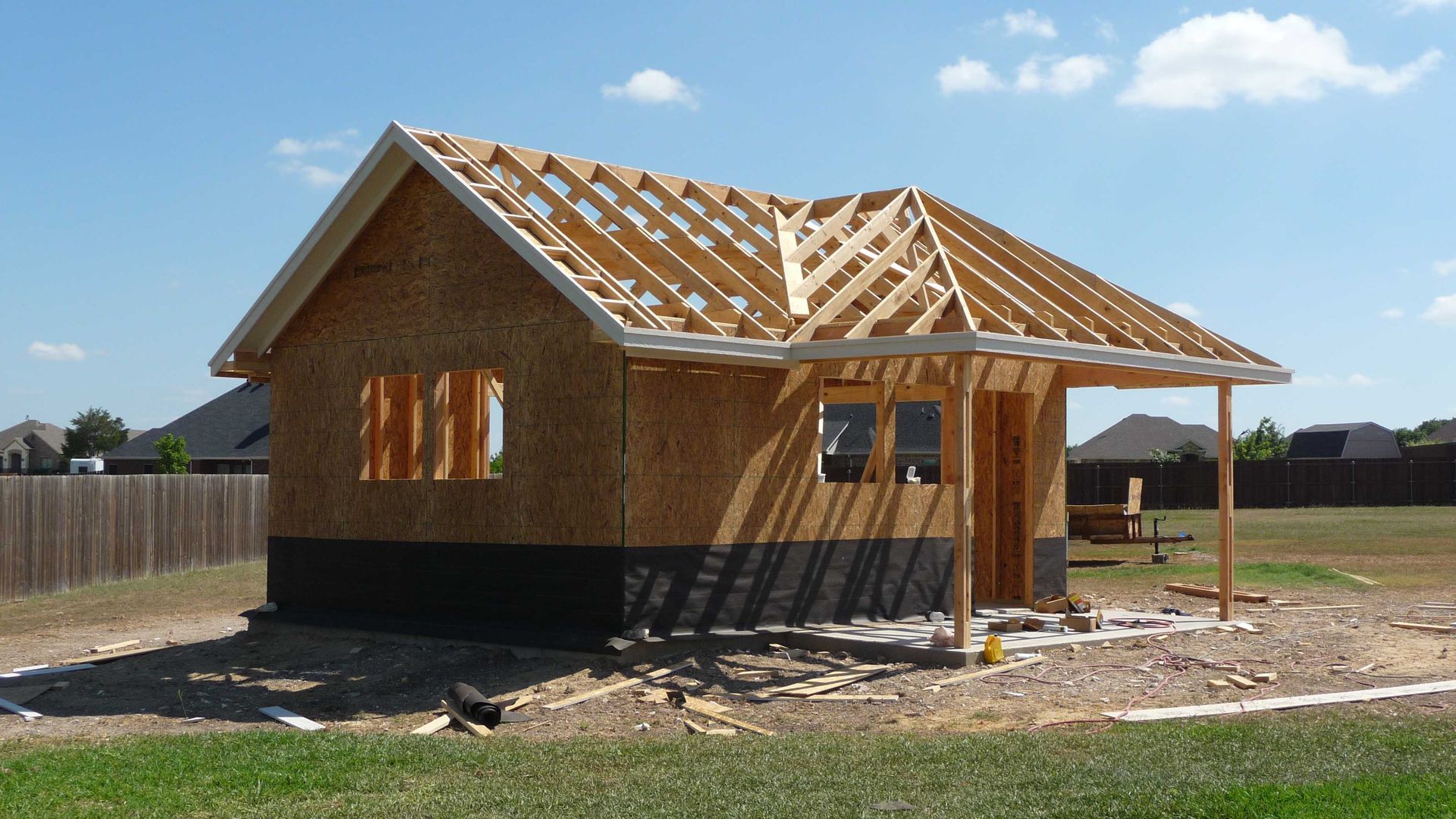A small wooden house is being built in a backyard