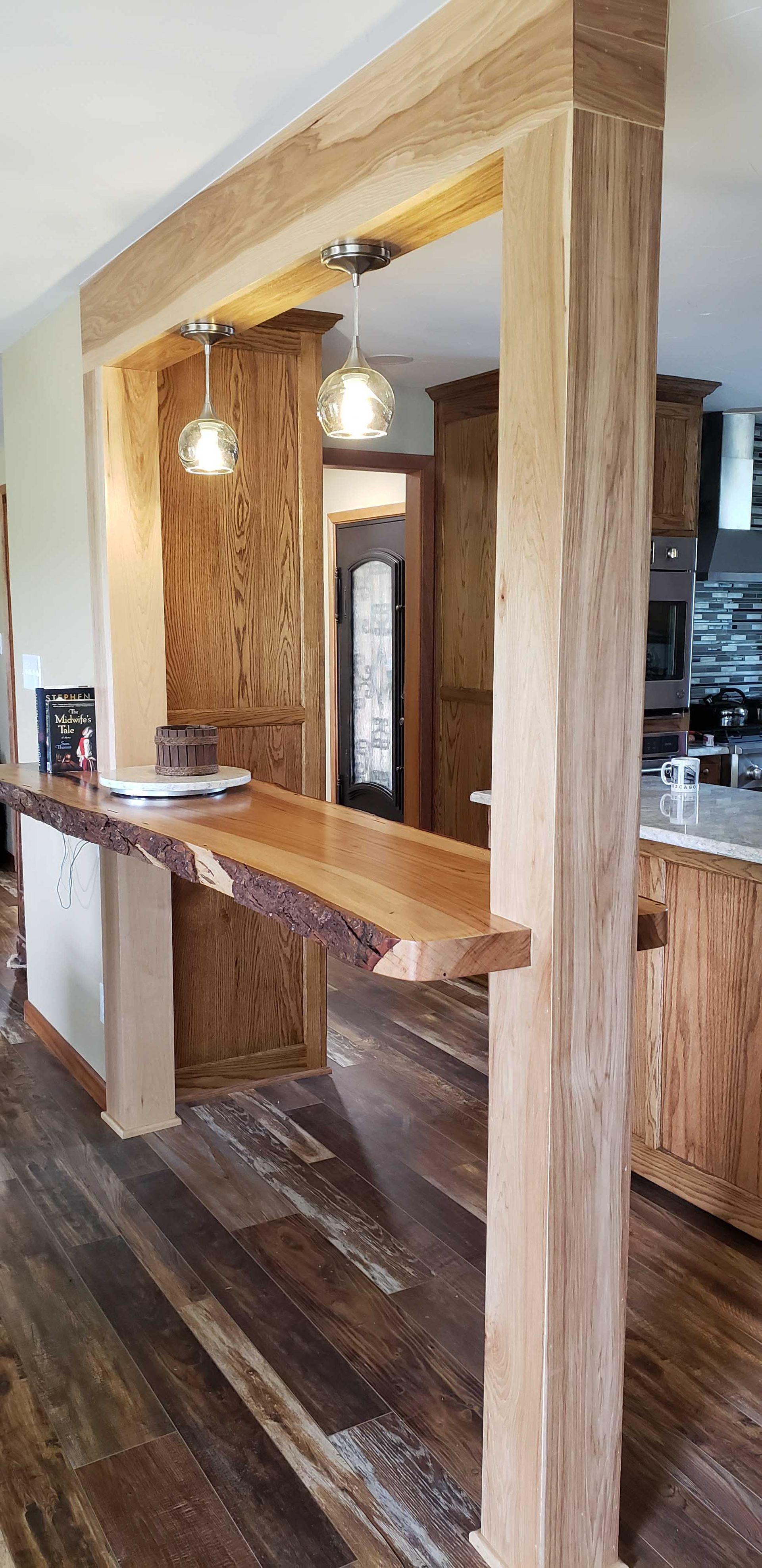 A kitchen with a wooden counter and a wooden pillar.