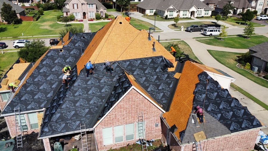 A group of people are working on the roof of a house.