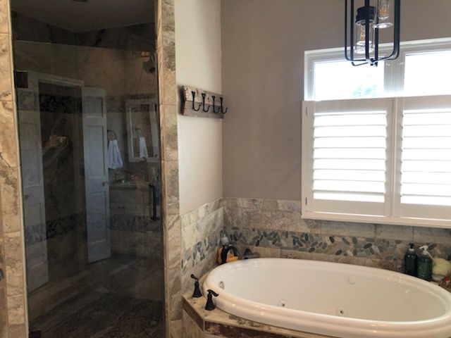 A bathroom with a jacuzzi tub and a walk in shower.