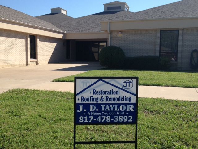 A sign for j.d. taylor restoration roofing and remodeling
