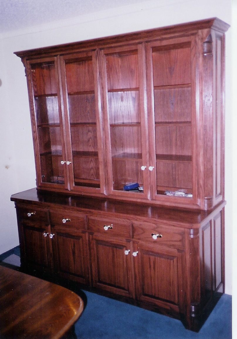 A large wooden cabinet with glass doors and drawers