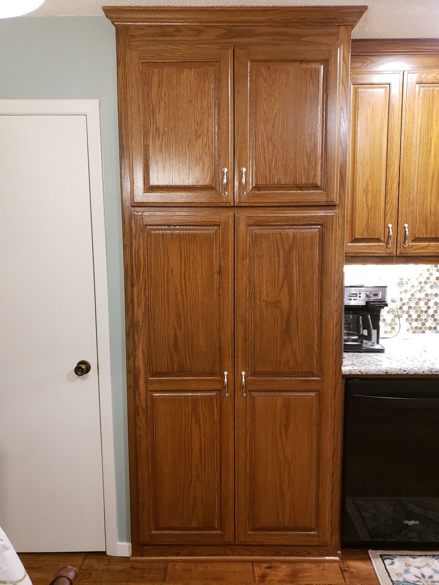 A kitchen with wooden cabinets and a black stove.