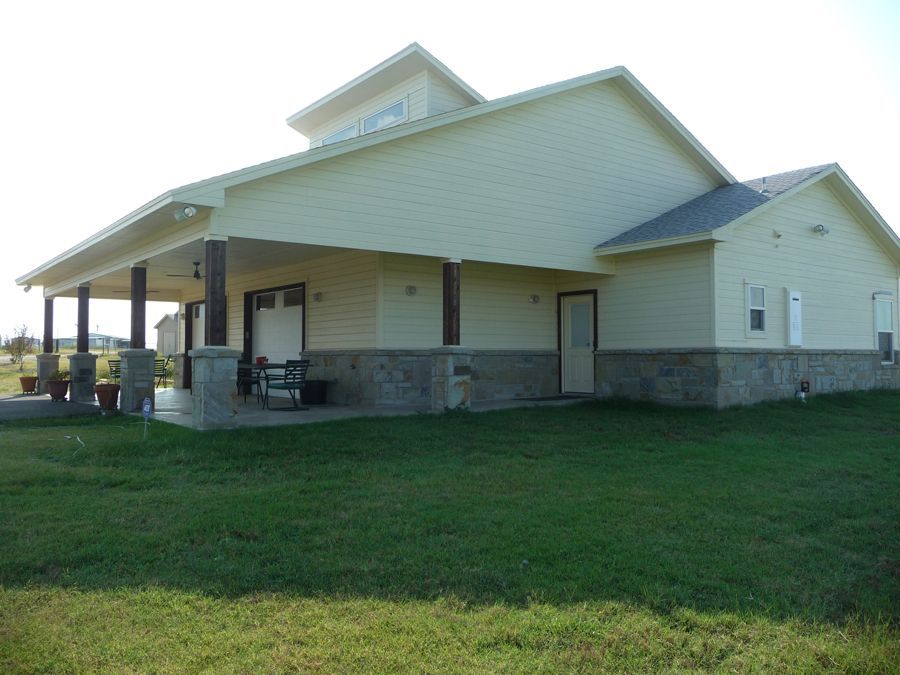A large white house with a porch and a bench