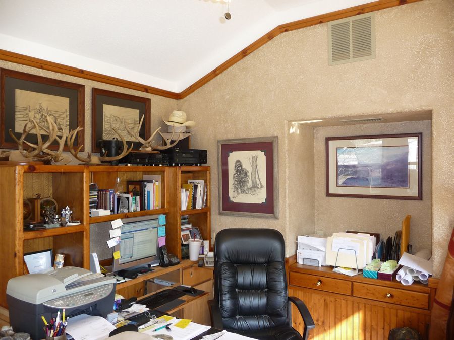 A home office with a black chair and a printer