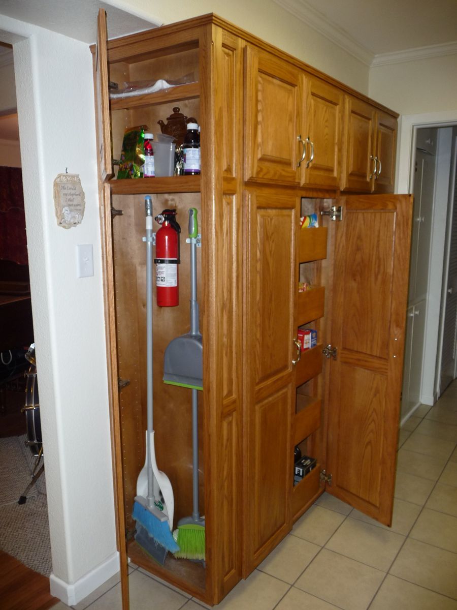 A cabinet with a fire extinguisher and a broom in it