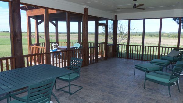 A screened-in porch with a table and chairs