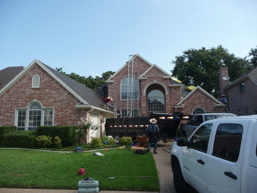A white truck is parked in front of a brick house