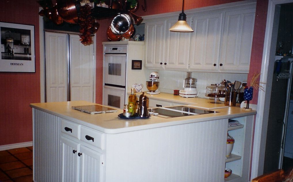 A kitchen with white cabinets and a large island