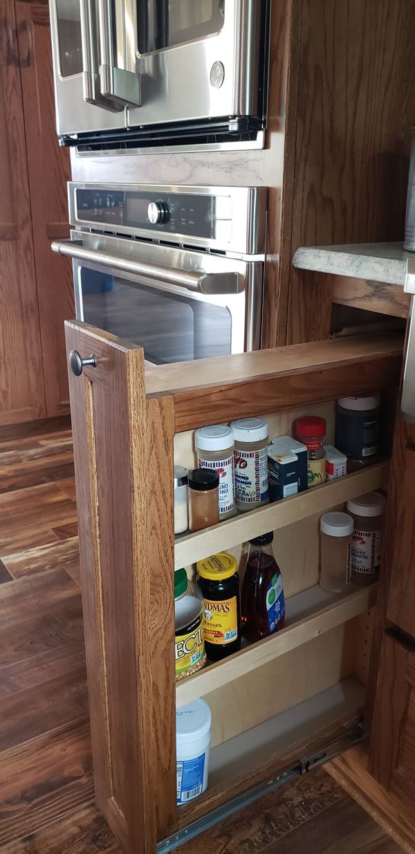 A kitchen with a stainless steel refrigerator and a wooden spice rack.