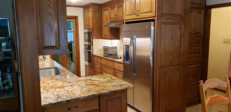 A kitchen with stainless steel appliances and wooden cabinets.
