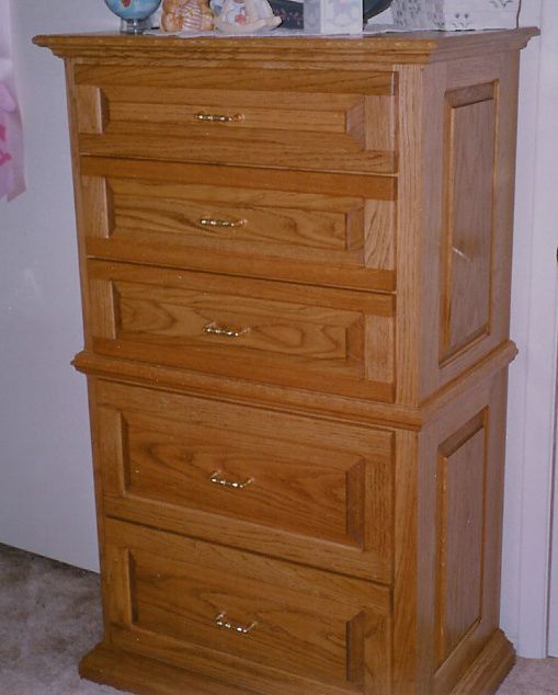 A wooden chest of drawers with gold handles