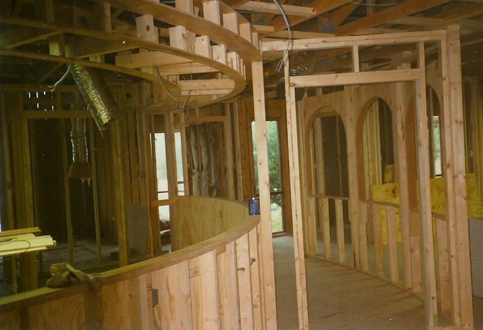 A wooden house is being built with a curved wall.