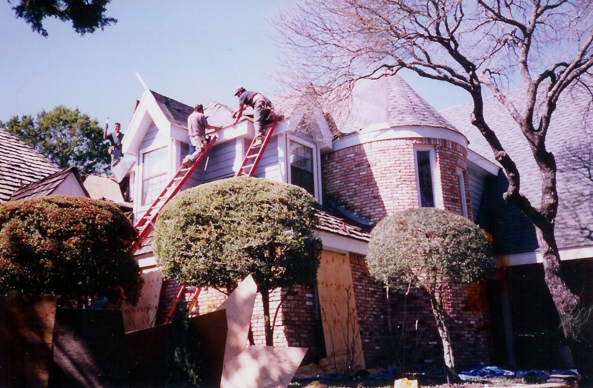 A group of men are working on the roof of a house