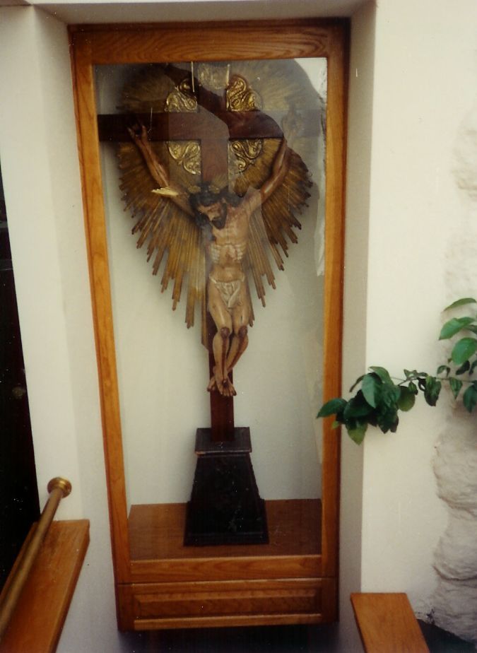 A statue of jesus on a cross in a glass case