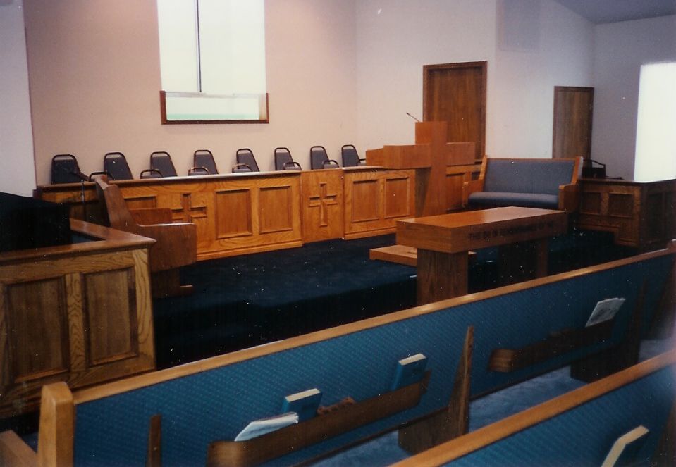 A church with blue benches and a wooden podium