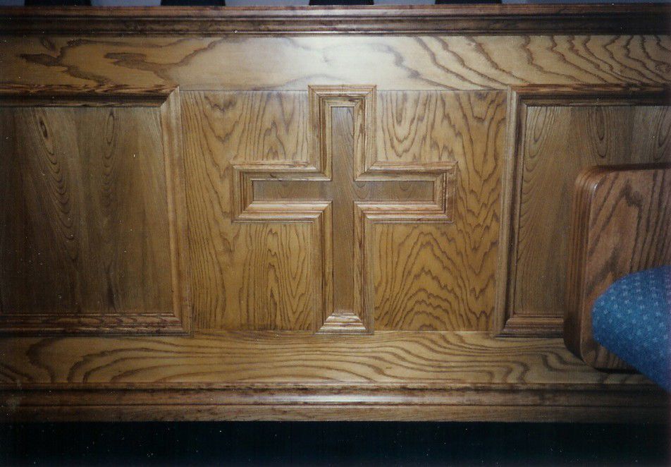 A wooden bench with a cross carved into it.
