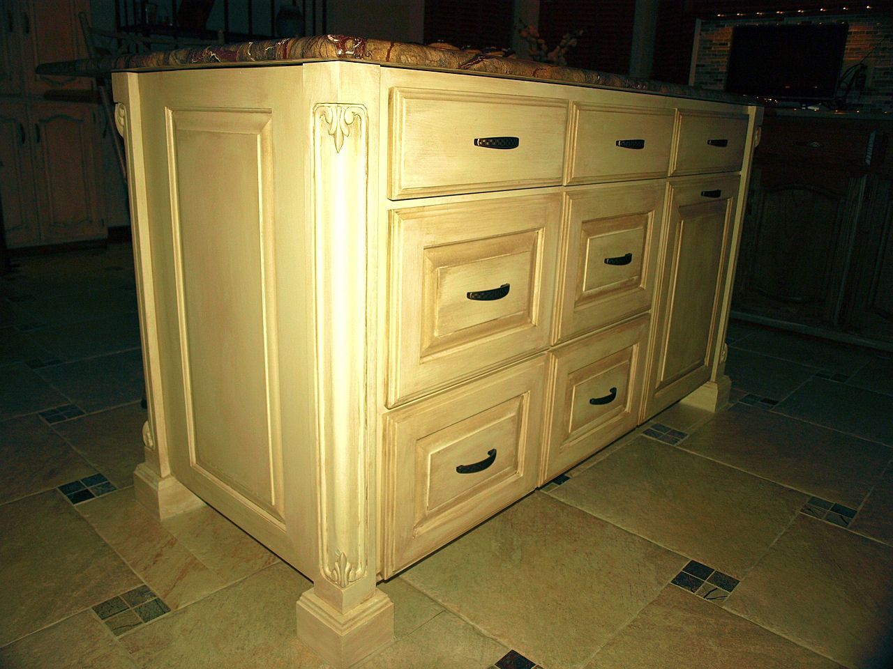 A kitchen island with drawers and a granite counter top