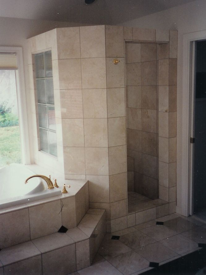 A bathroom with a tub and a walk in shower
