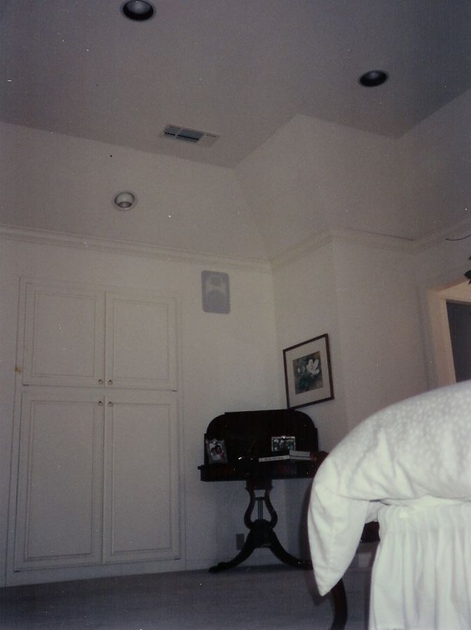 A bedroom with a desk and a picture on the wall