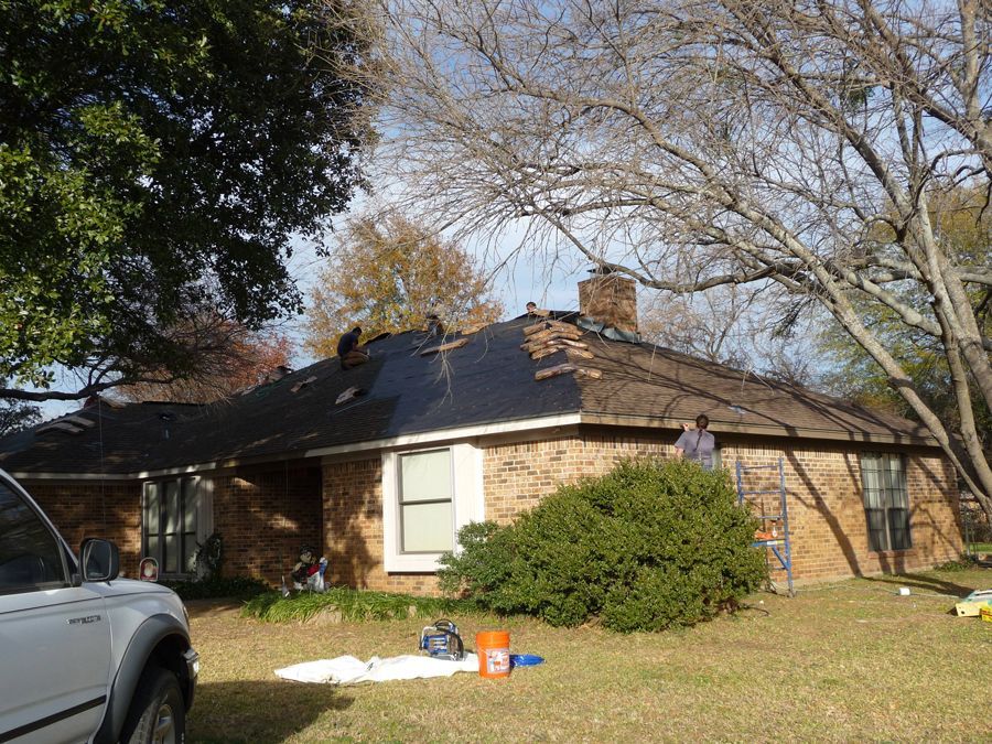 A white truck is parked in front of a brick house