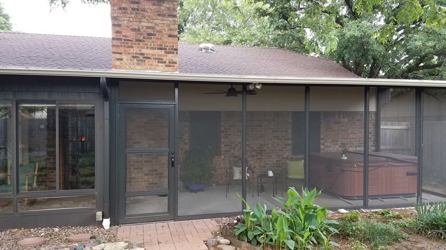 A house with a screened in porch and a hot tub.