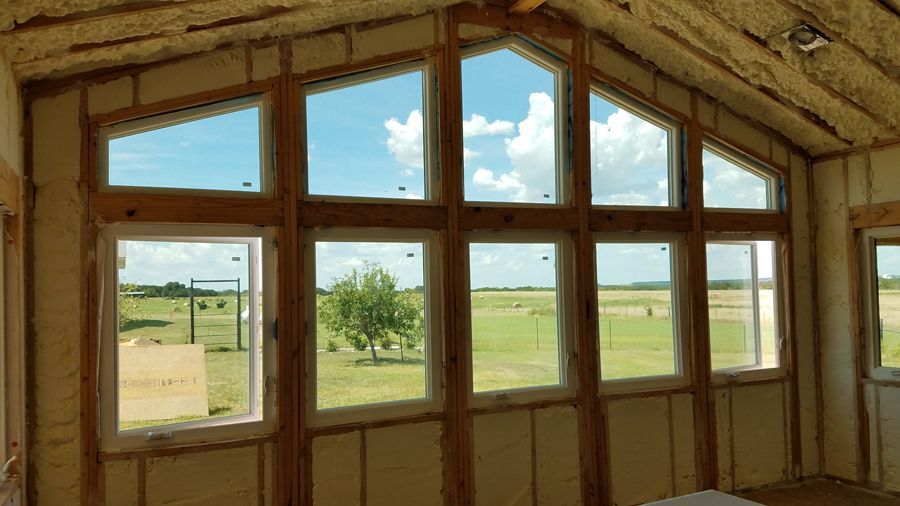 A room with a lot of windows and a view of a field.