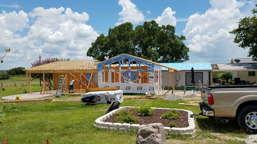A truck is parked in front of a house under construction.