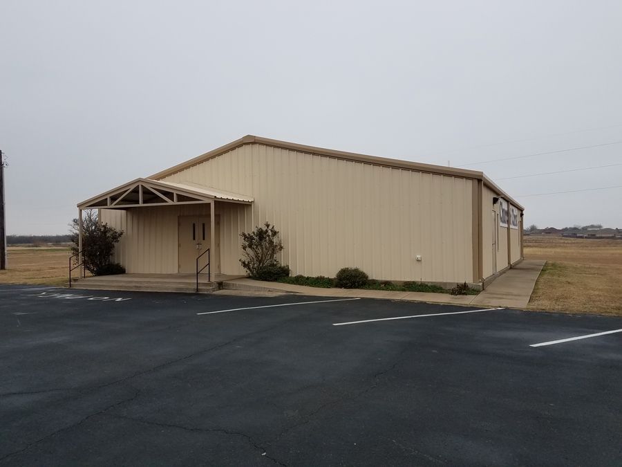 A large building with a canopy is sitting in the middle of a field.