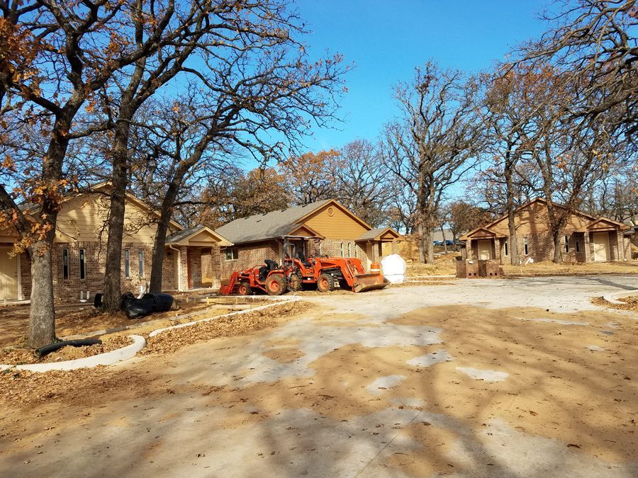 A tractor is parked in front of a house under construction.