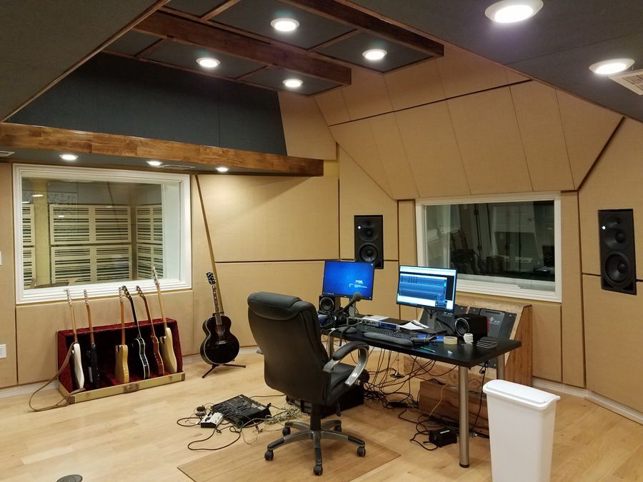 A recording studio with a chair and a computer