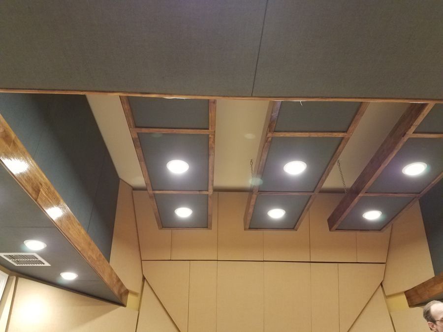 A man is standing in a room with a ceiling that has a lot of lights on it