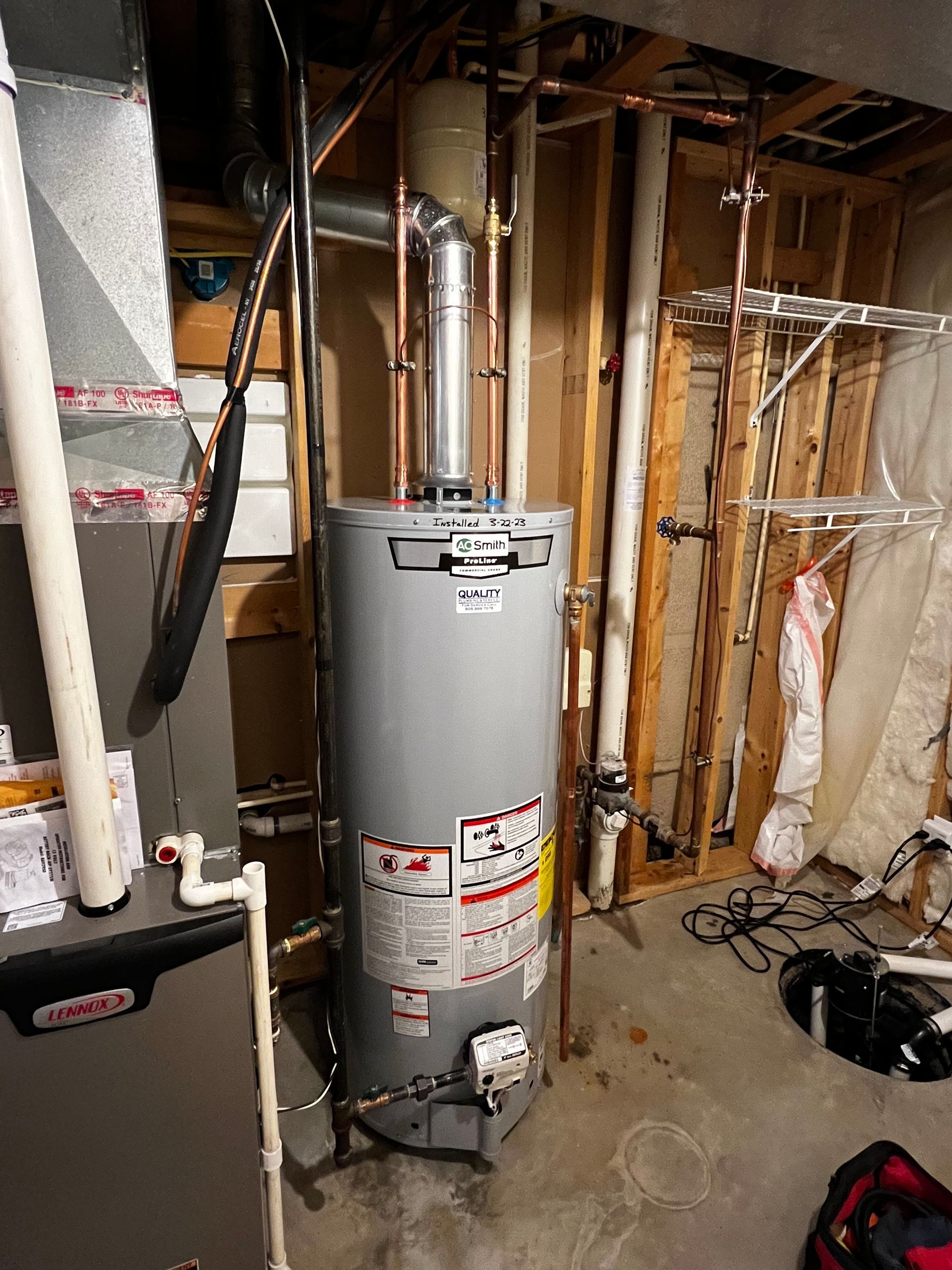 Water heater and furnace in a basement setting with copper pipes and ventilation.