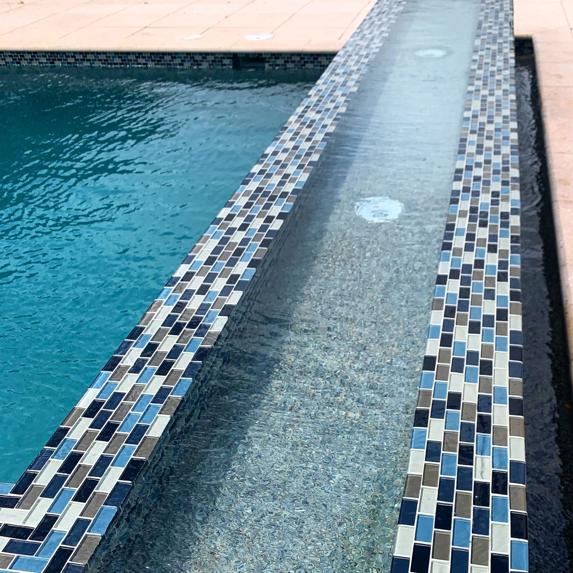 A swimming pool with blue and white tiles on the edge