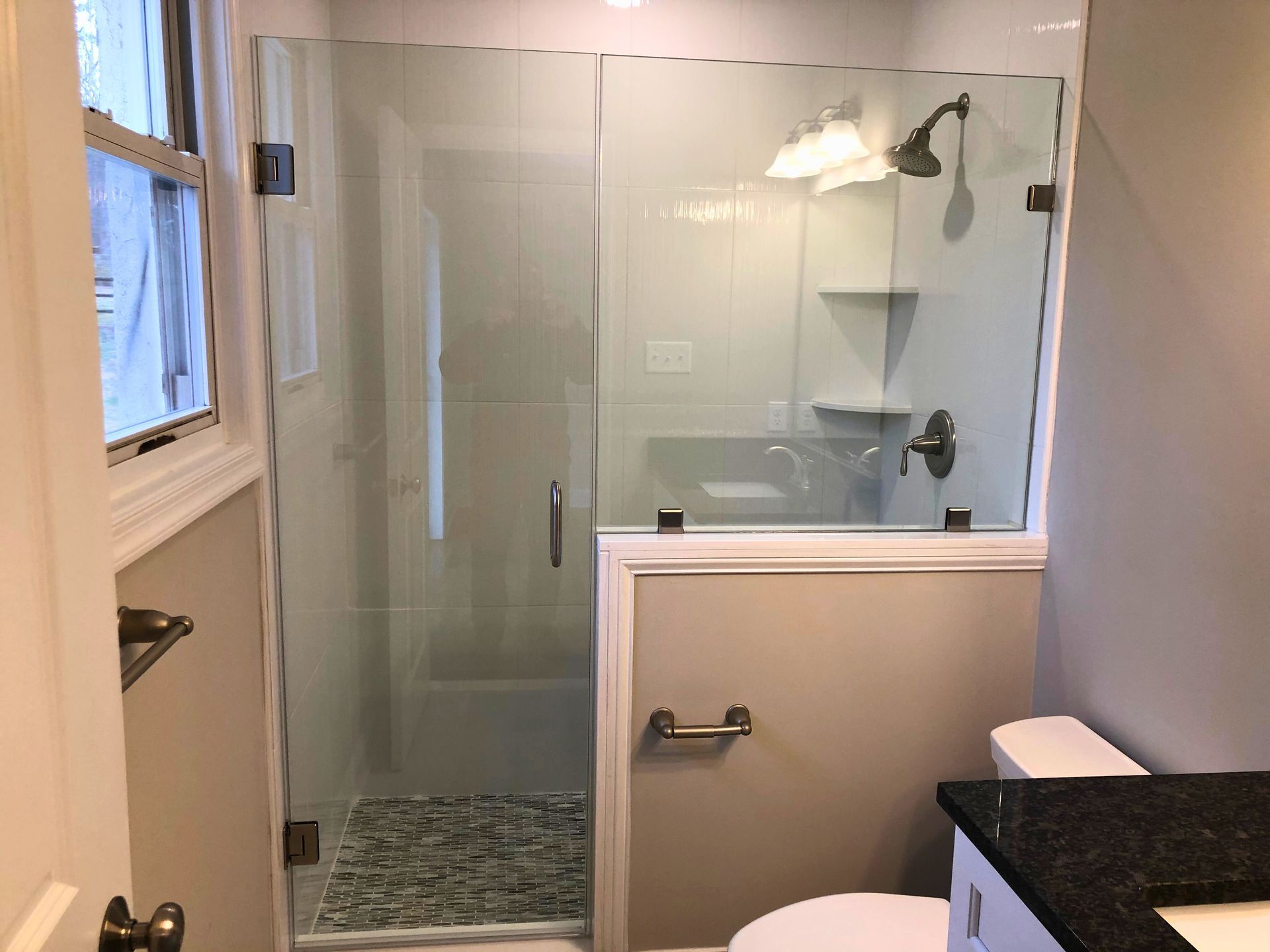 Bathroom with glass shower, gray walls, white trim, and a toilet.