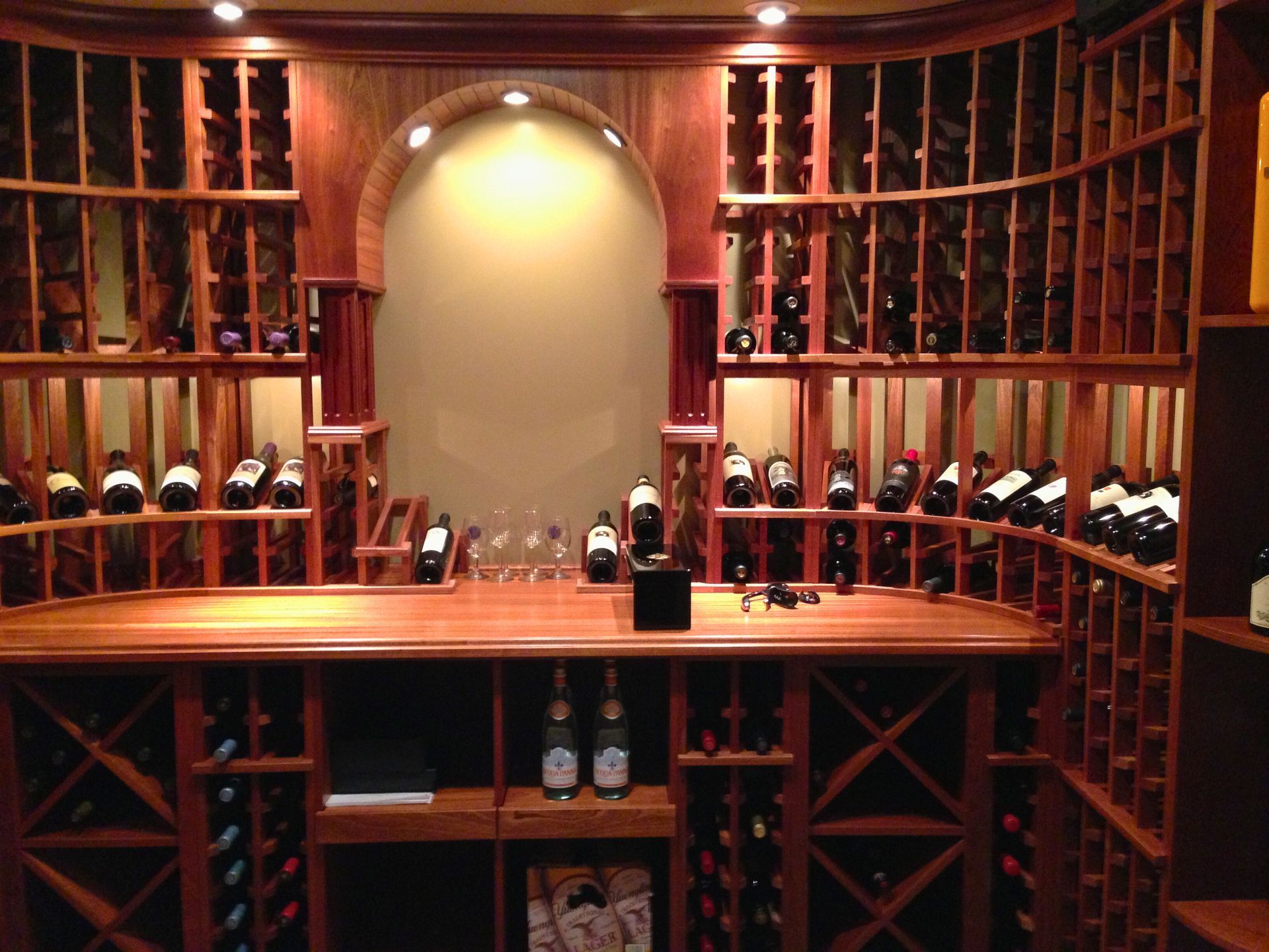 Wine cellar with wooden racks, bottles, and countertop.
