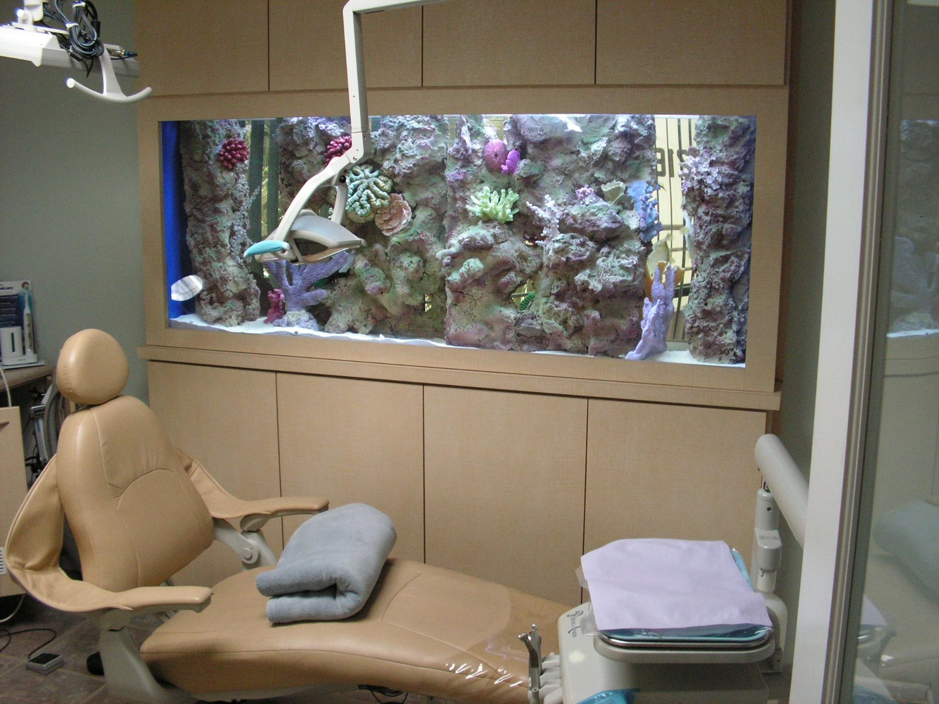 Dental chair in a dentist's office with an aquarium built into the wall.