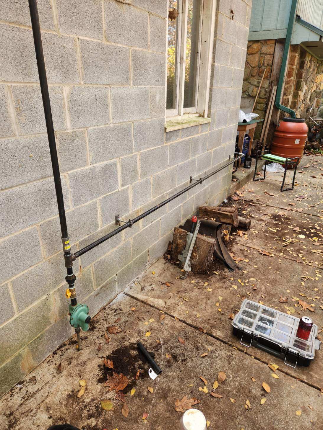 A pipe is being installed on the side of a brick building.