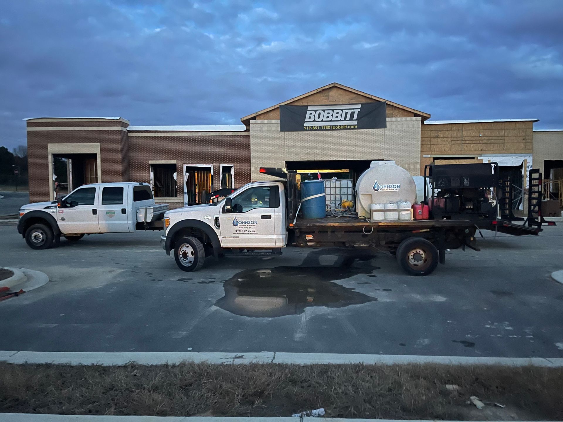 Two trucks are parked in front of a building.