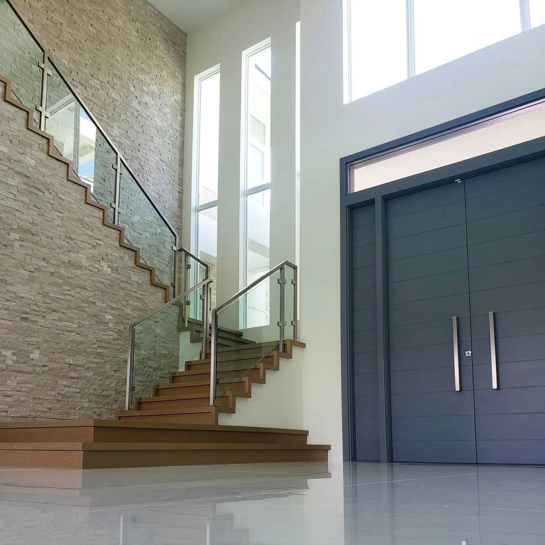 A staircase with a glass railing and a door