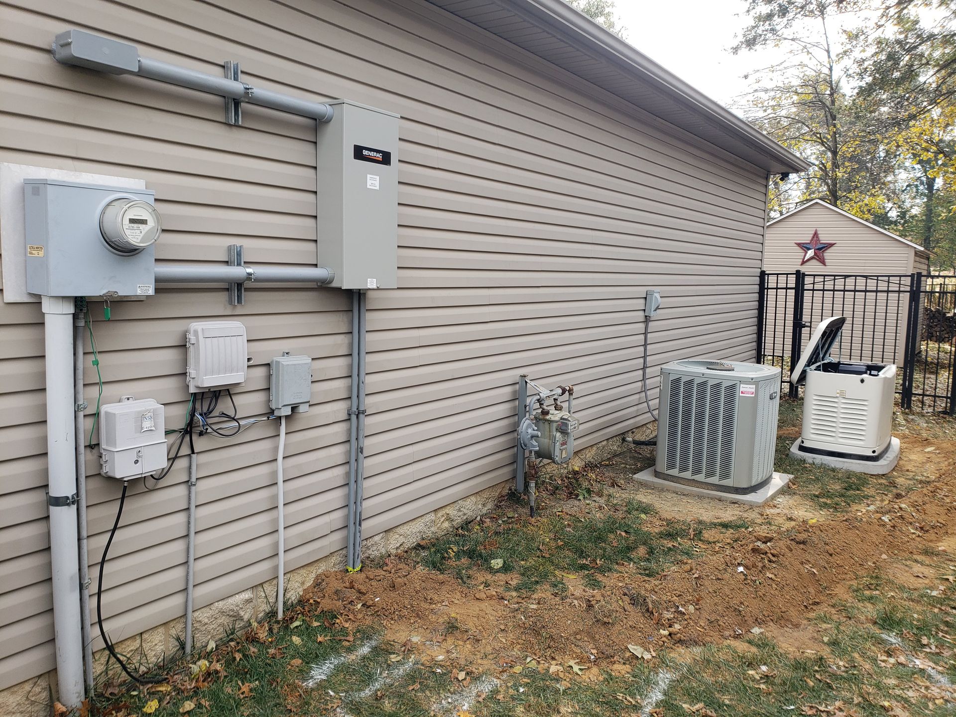Exterior wall with electrical equipment: meter, boxes, pipes, air conditioner, and generator.