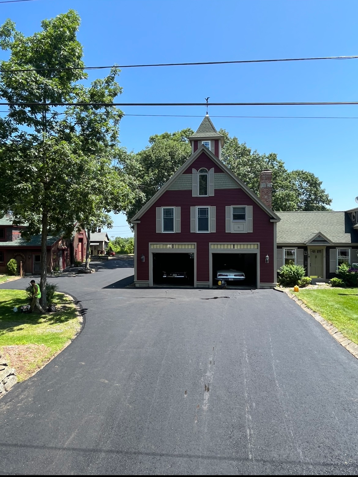 A red barn with two cars parked in front of it