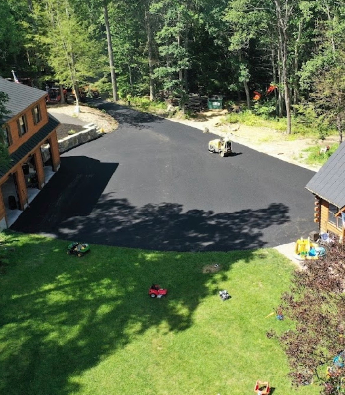 A dirt road going through a forest with trees on both sides.