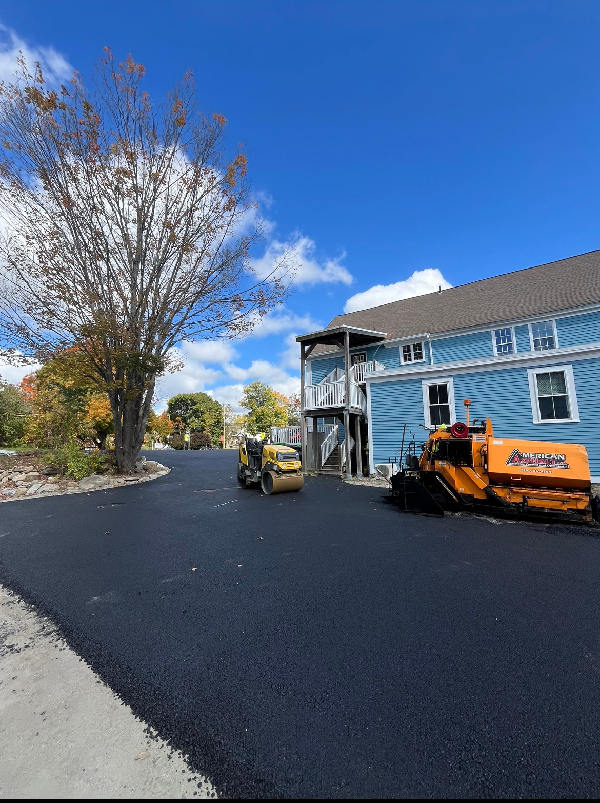A blue house with a yellow machine in front of it