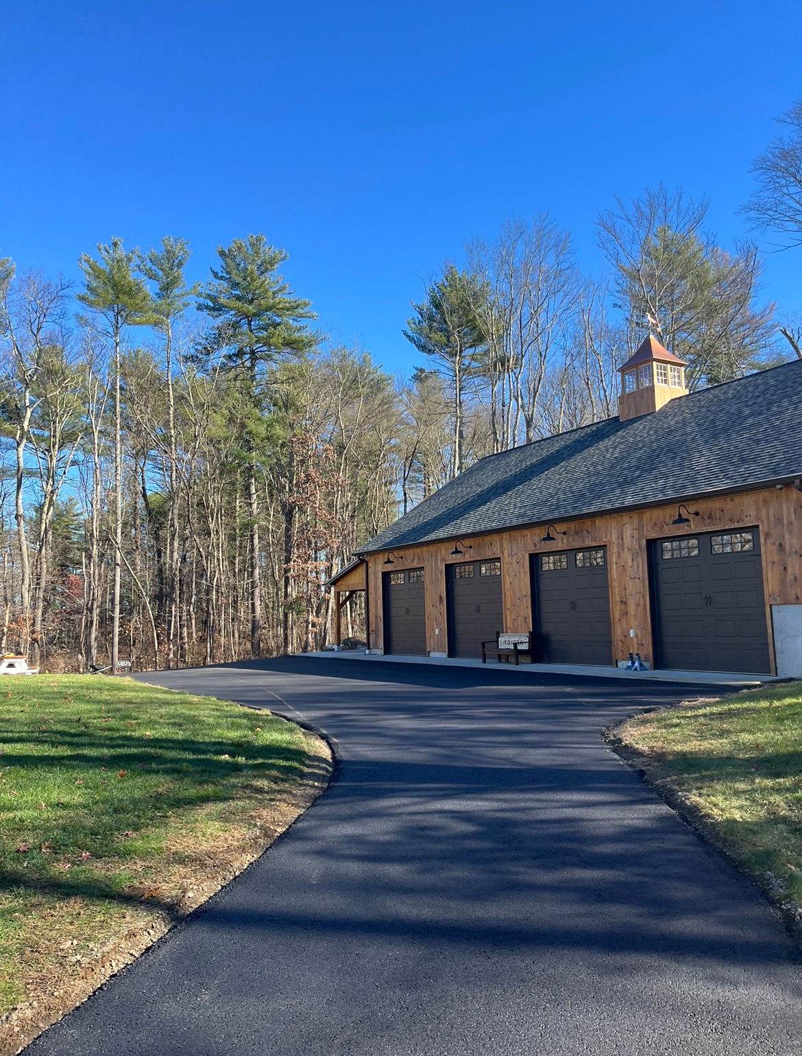 A driveway leading to a house with a lot of garage doors.
