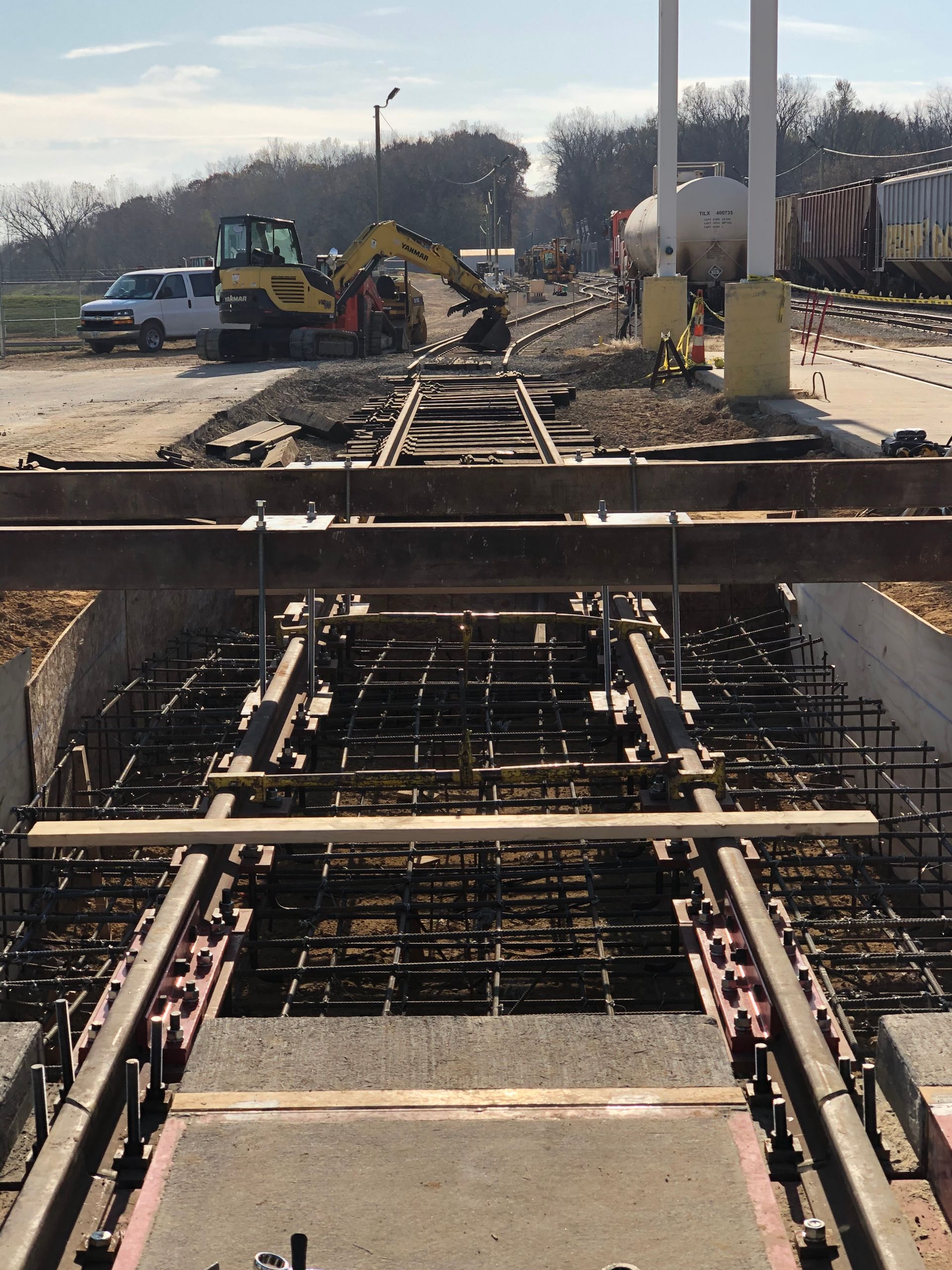 A train track under construction with a yellow excavator in the background